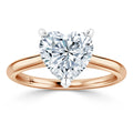 A gold ring with a large, heart-shaped diamond in a prong setting on a plain band.