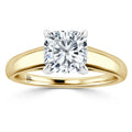 A yellow gold ring with a large, round cushion-cut diamond set in a four-prong white gold setting.