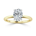 Gold band solitaire ring with an oval-cut diamond in a four-prong setting, on a white background.