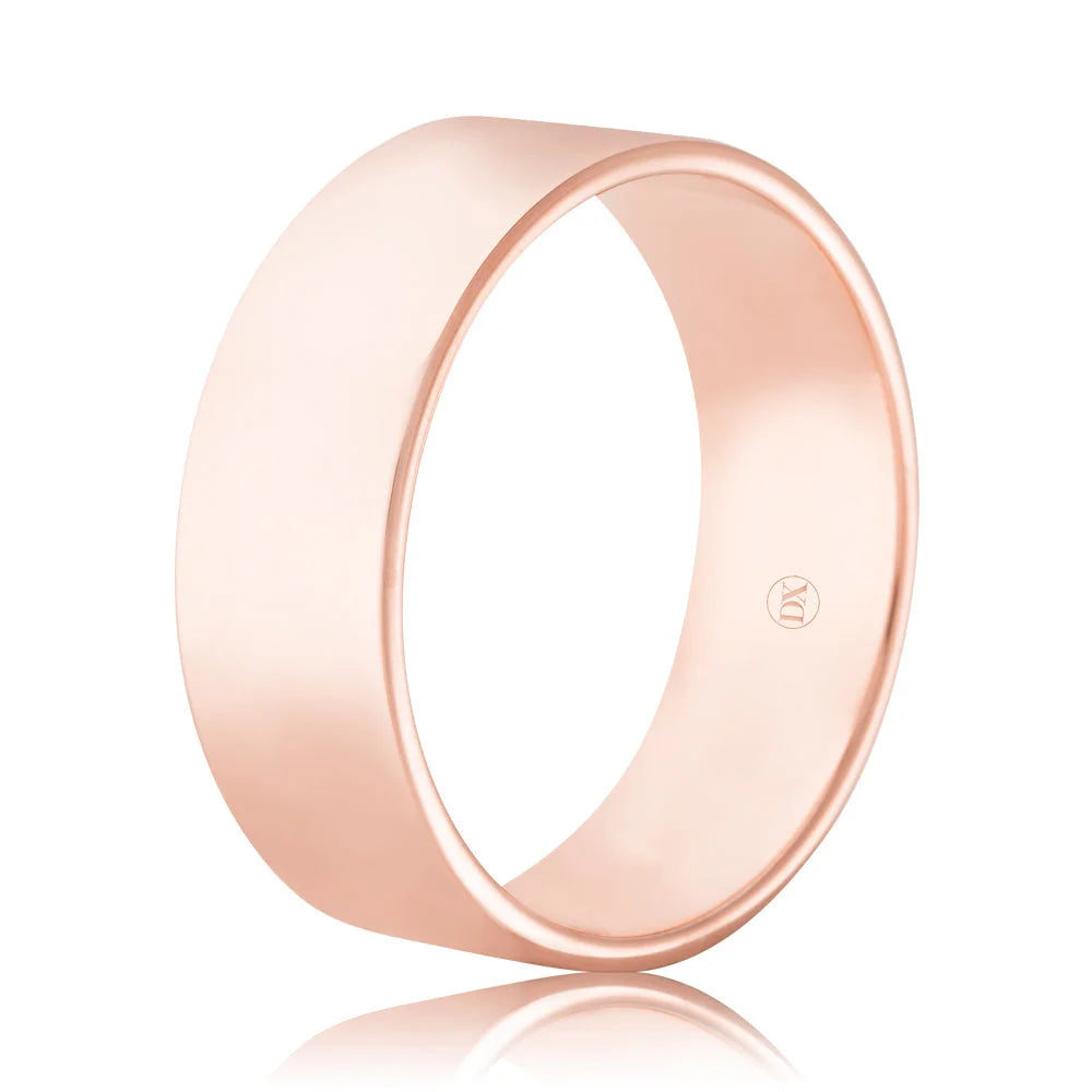 Simple rose gold wedding band with a smooth, matte finish and a small engraved logo on the inner surface.