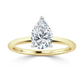 Gold band ring with a large, pear-shaped diamond solitaire set in a simple prong setting, on white background.