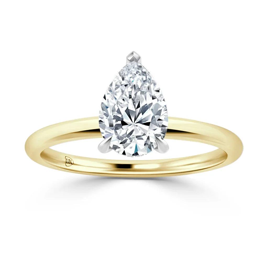 Gold band ring with a large, pear-shaped diamond solitaire set in a simple prong setting, on white background.