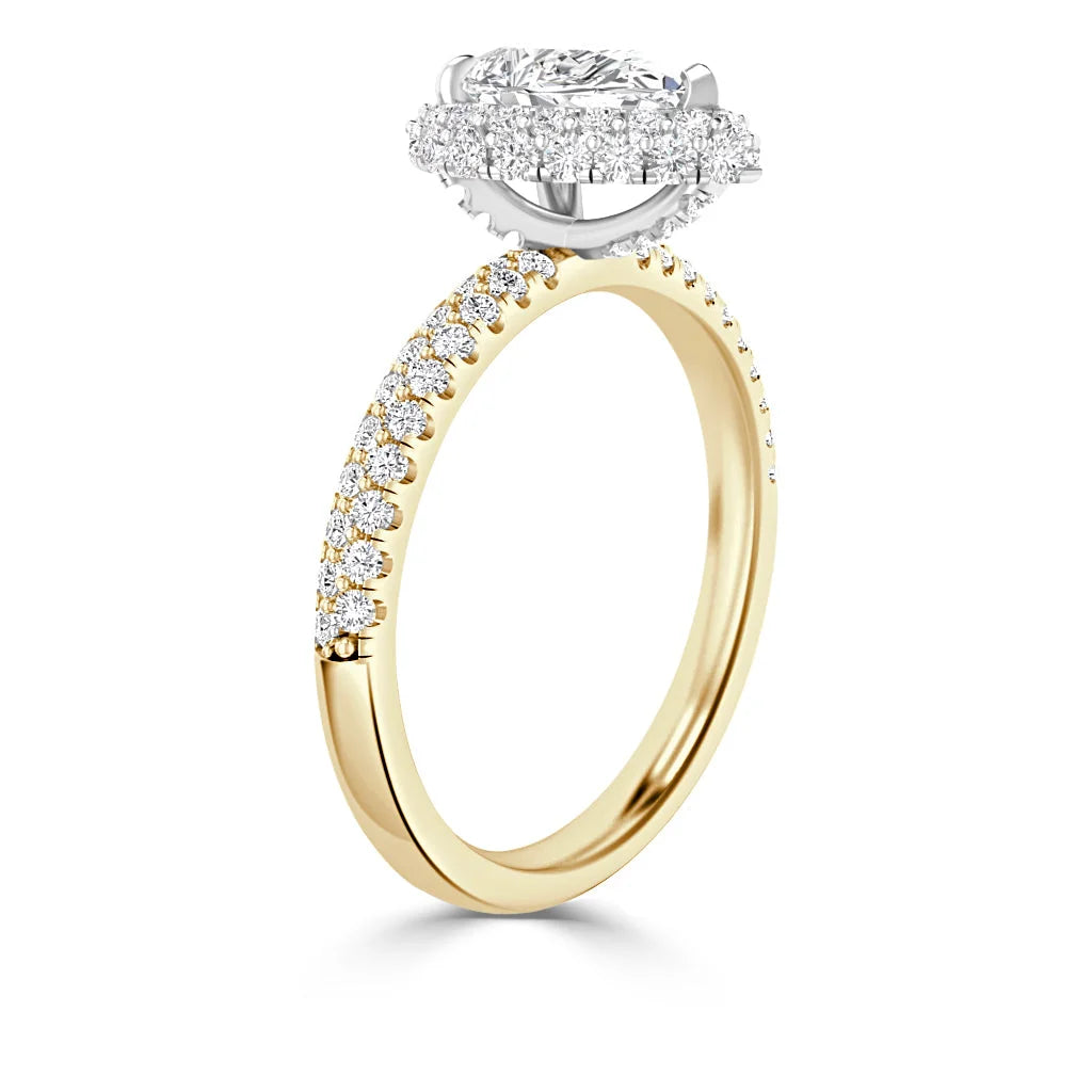 Gold ring with oval diamond halo setting and small diamonds along the band, shown on a white background.