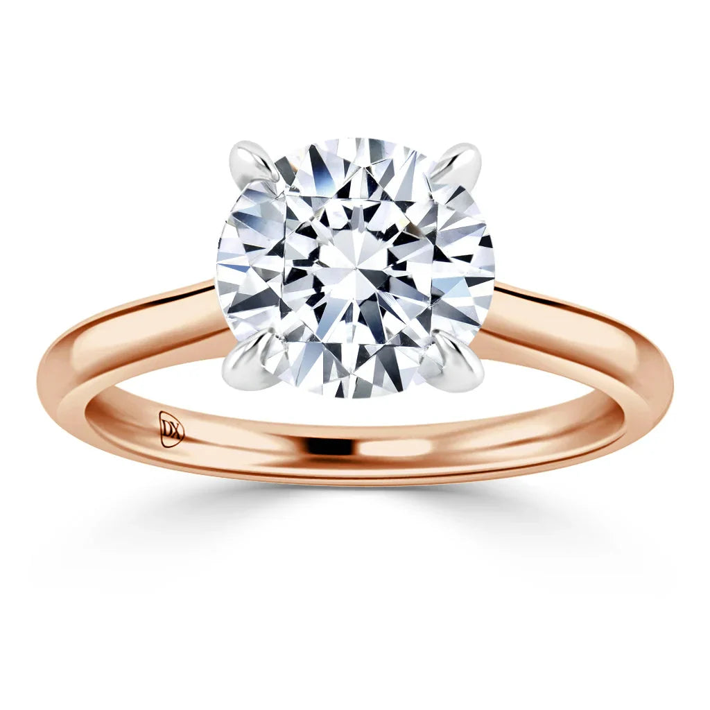 A round-cut diamond solitaire ring with a rose gold band and four prongs on a white background.