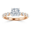 Rose gold ring with a square-cut center diamond and round diamonds set along the band.