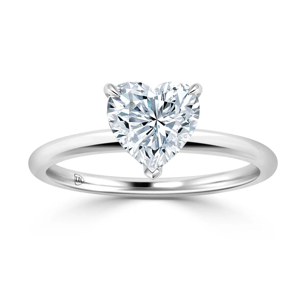 A solitaire ring with a heart-shaped diamond set on a simple, polished silver band.