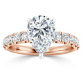 Pear-shaped diamond ring with rose gold band and round diamonds set along the band, on white background.