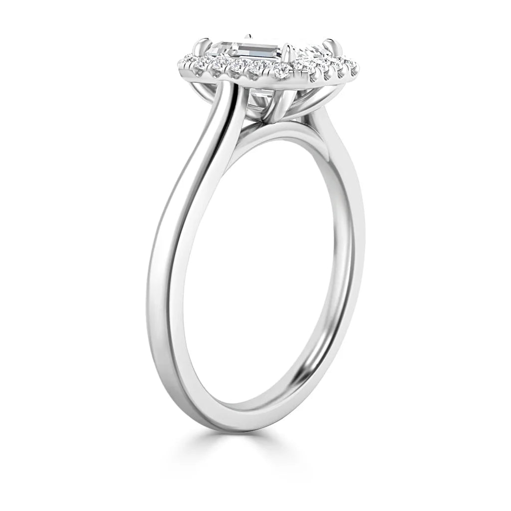 A white gold ring with a rectangular center stone and a halo of small round diamonds, shown from a side angle.