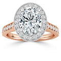 Oval diamond halo engagement ring with rose gold band and smaller diamonds around the center stone.