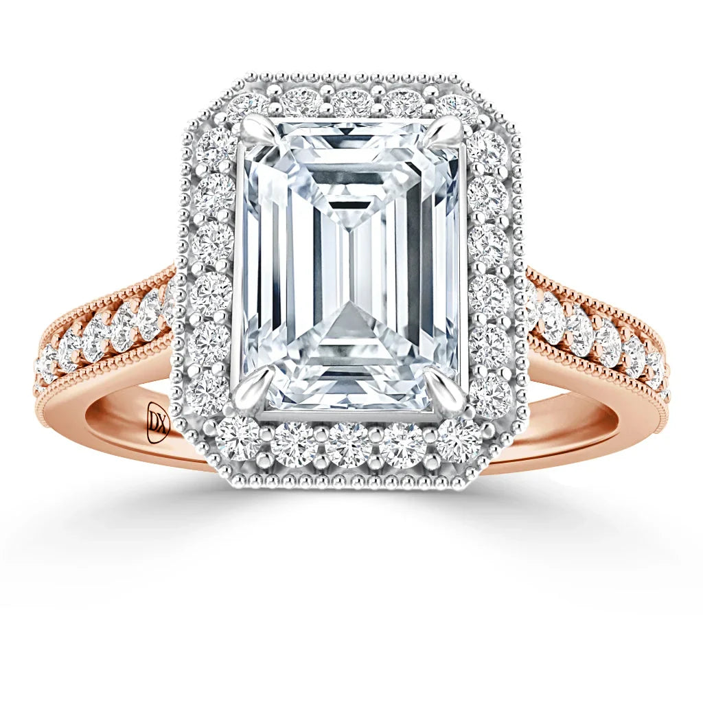 Emerald-cut diamond ring with halo of smaller diamonds, rose gold band, and intricate side detailing.