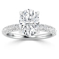 A white gold ring with a large oval diamond center stone and smaller diamonds on the band.