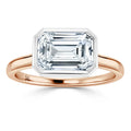 Rose gold ring with a large emerald-cut diamond in a bezel setting, viewed from the front on a white background.
