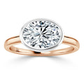 Oval-cut diamond solitaire ring with a rose gold band and a white bezel setting, shown on a white background.