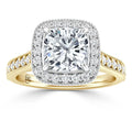 Cushion-cut diamond ring with a diamond halo on a gold band featuring small diamonds and intricate detailing.