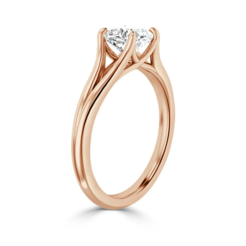 Rose gold ring with a round solitaire diamond in a unique twisted prong setting, shown on a white background.