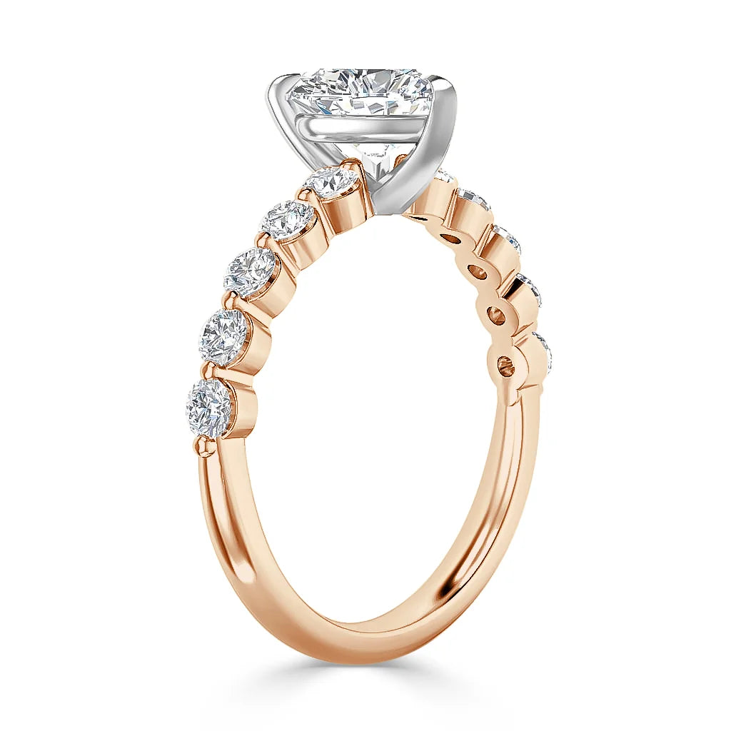 Rose gold ring with a round diamond center stone and side diamonds set along the band in prong settings.