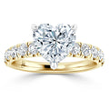 Gold ring with a heart-shaped diamond center stone and round diamonds set along the band.