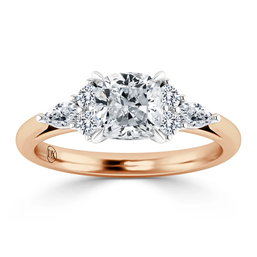 A rose gold ring with a cushion-cut center diamond flanked by two round and two marquise side diamonds.