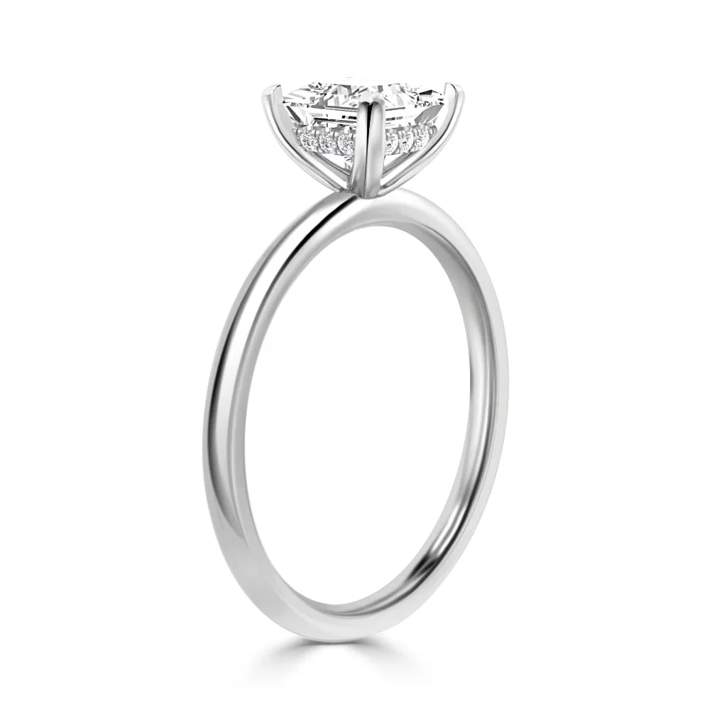 A solitaire diamond engagement ring with a thin silver band and a round diamond in a prong setting.