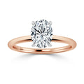 A rose gold ring with a large oval-cut diamond solitaire set in a simple prong setting against a white background.