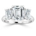 Platinum ring with three emerald-cut diamonds, the center stone larger than the two side stones.
