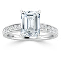 Emerald-cut diamond ring with a pavé band of smaller diamonds set in platinum, shown on a white background.