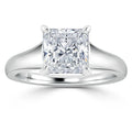 A solitaire ring with a princess-cut diamond set on a simple white gold band against a white background.