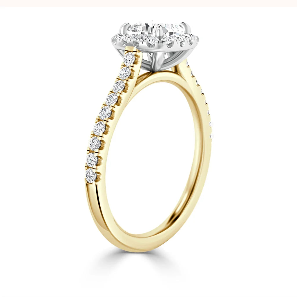 A gold ring with a round diamond halo setting and small diamonds along the band, viewed from the side.