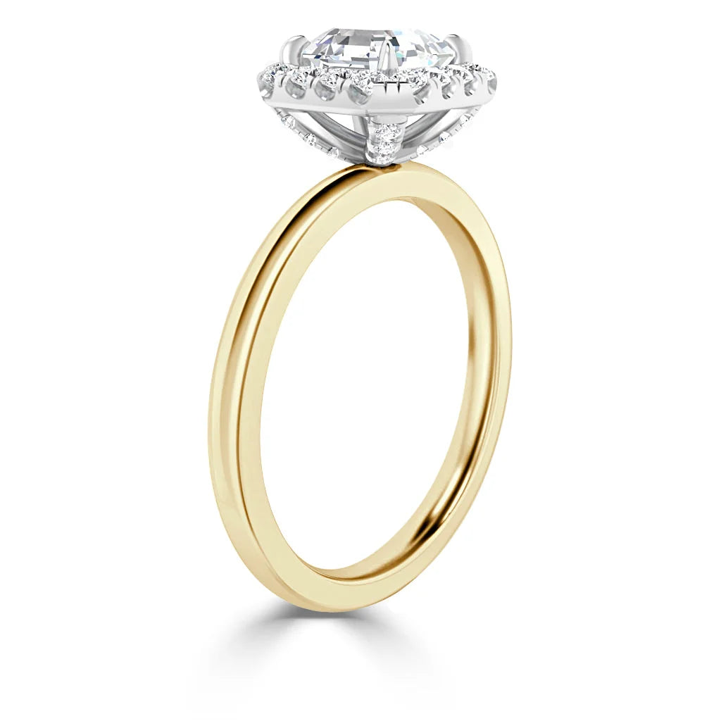 A gold ring with a large round diamond in a white gold setting, viewed from the side on a white background.