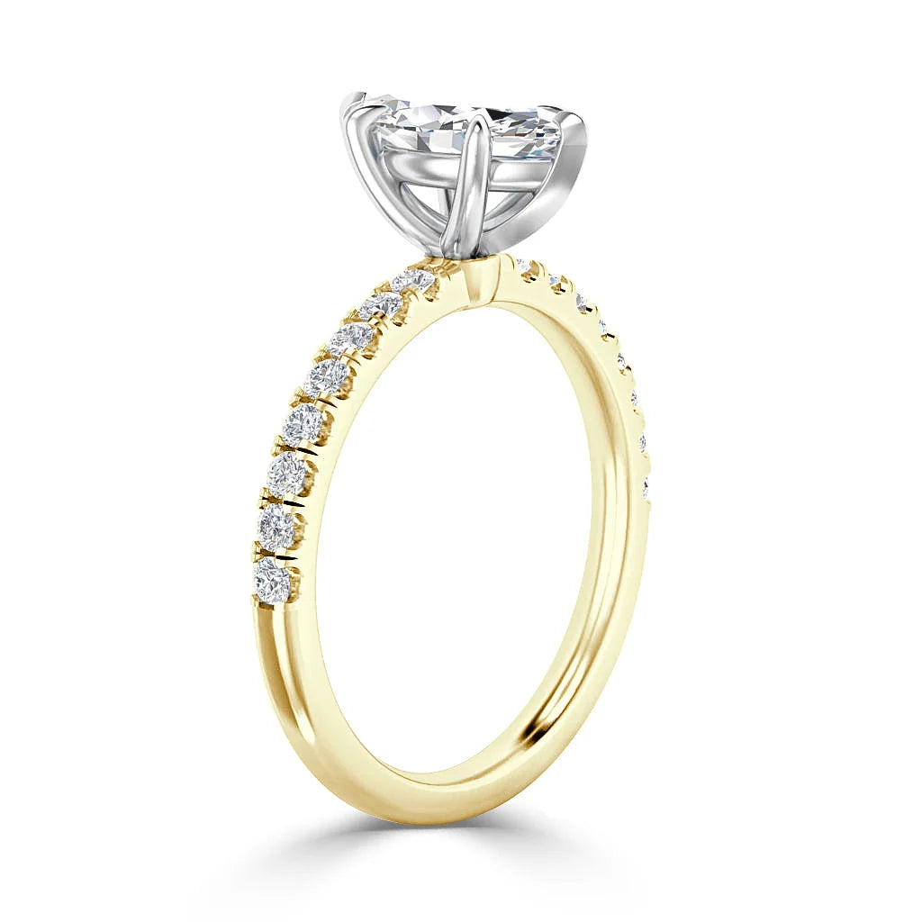 A gold ring with a round diamond solitaire and smaller diamonds set along the top half of the band.