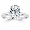 Oval-cut diamond solitaire ring with a simple silver band on a plain white background.