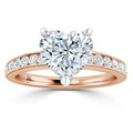 A rose gold ring with a heart-shaped diamond center and smaller diamonds along the band.