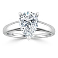A silver ring with a large, pear-shaped clear diamond solitaire set on a plain, polished band.