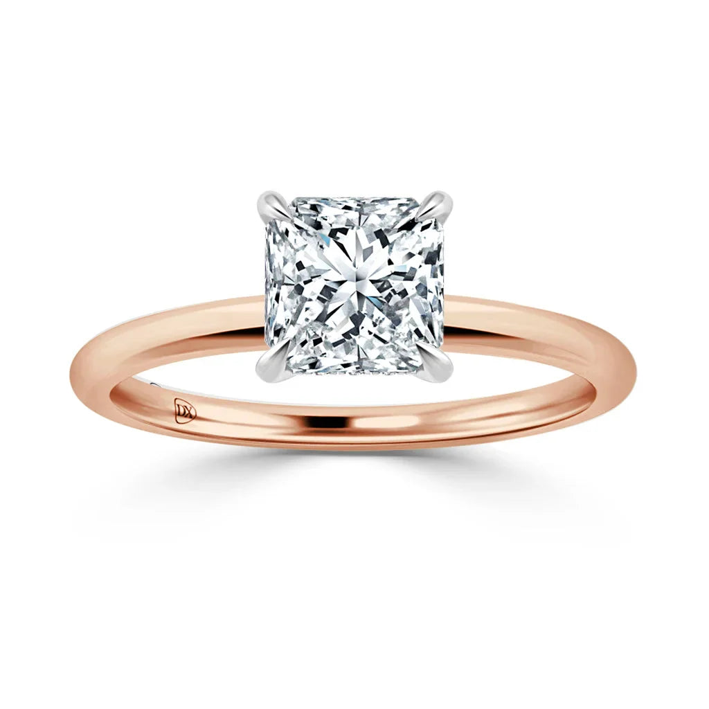 Rose gold ring with a square-cut diamond solitaire set in four prongs on a plain band.