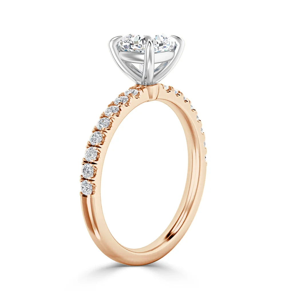 Rose gold ring with small diamonds on the band and a large round diamond in a white gold prong setting.