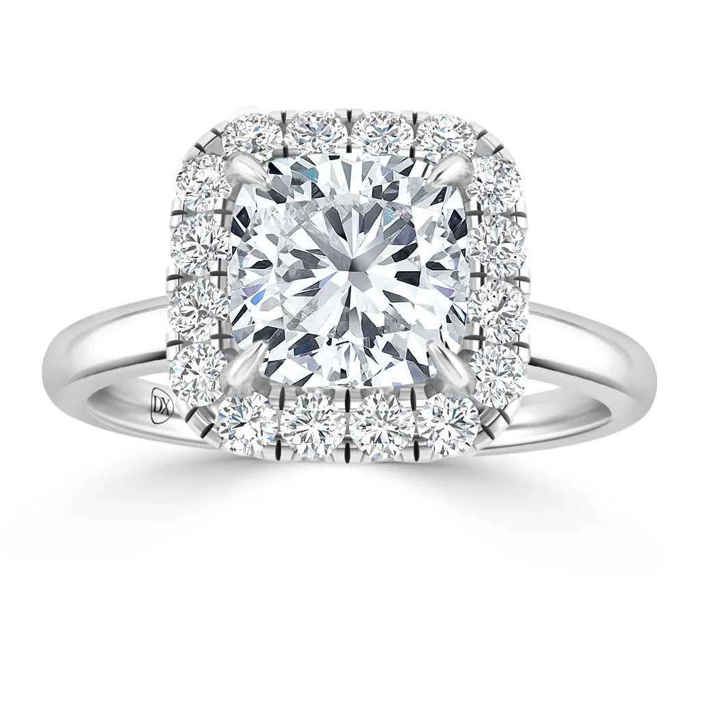 A white gold ring with a cushion-cut center diamond, surrounded by a halo of smaller round diamonds.