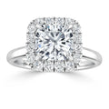 A white gold ring with a cushion-cut center diamond, surrounded by a halo of smaller round diamonds.