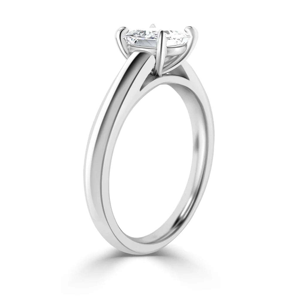 A solitaire diamond ring with a sleek, polished white gold band and a round diamond in a four-prong setting.