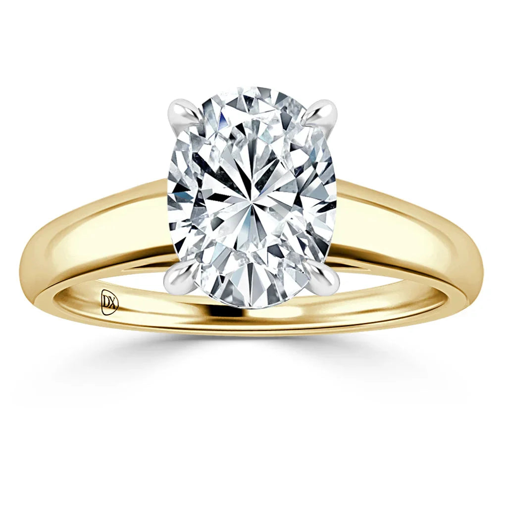 A gold band ring with an oval-cut diamond solitaire held by four prongs against a white background.