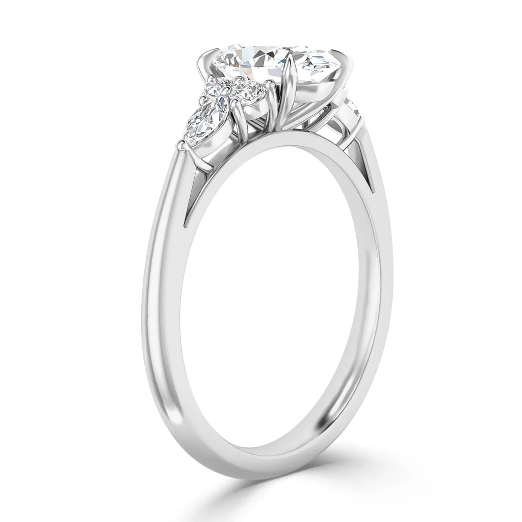 A silver ring with a round center diamond and two smaller marquise-shaped side diamonds on a sleek band.