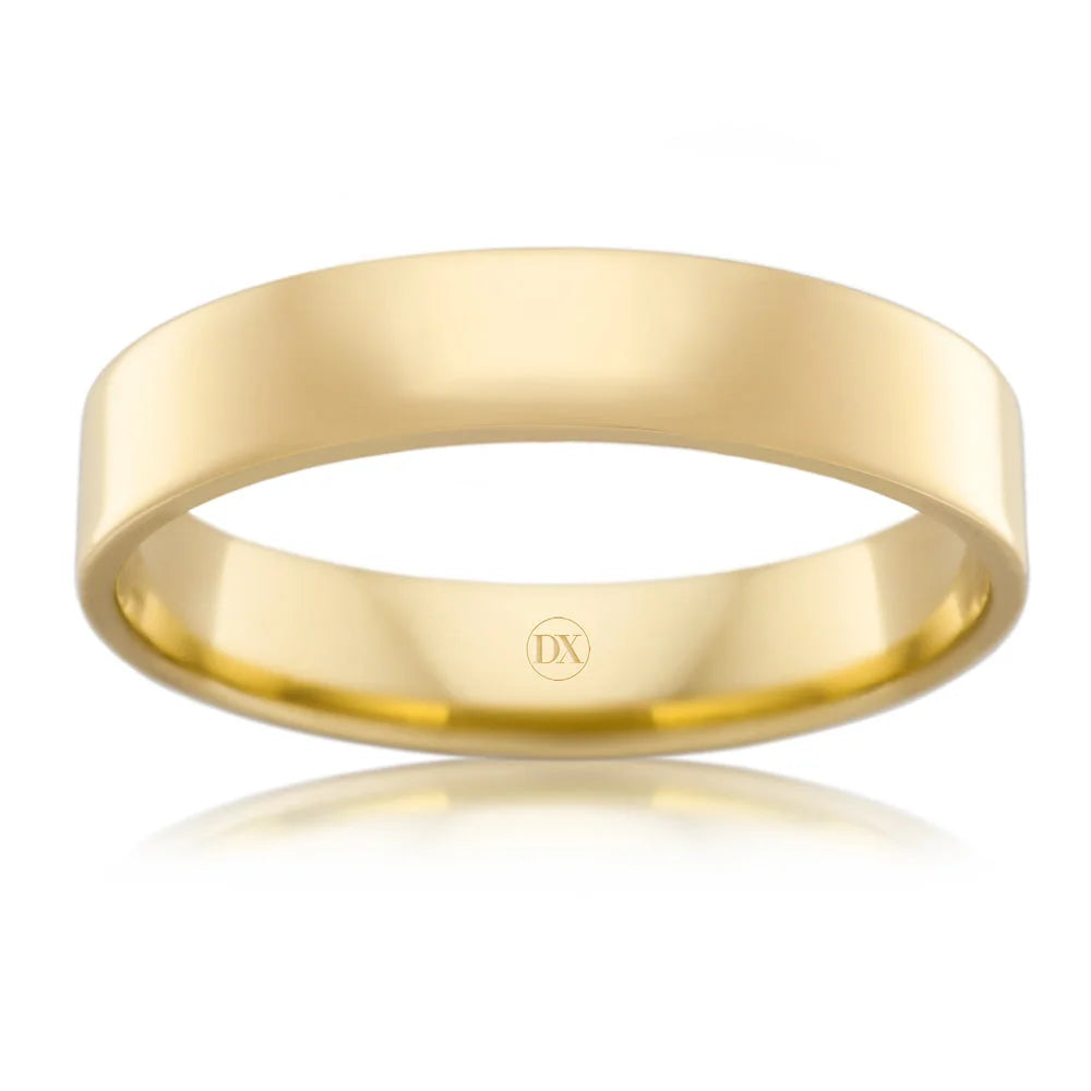 A plain, polished yellow gold ring with a smooth finish and DX engraved on the inside band.
