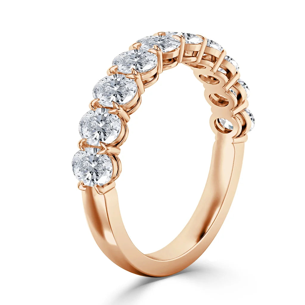 Rose gold ring featuring a row of round-cut diamonds in prong settings, shown on a white background.