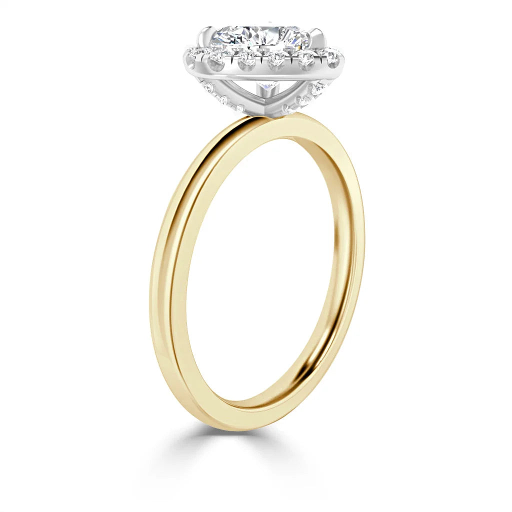 Gold ring with a round diamond halo setting in white gold, viewed from the side on a white background.