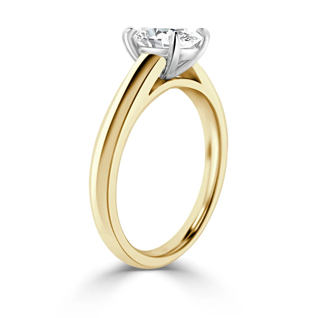 A gold band ring with a single round diamond in a silver prong setting, shown on a white background.
