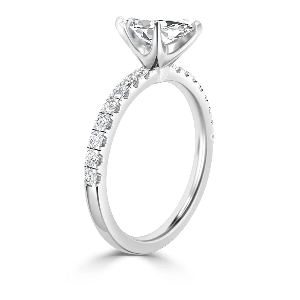A white gold ring with a round solitaire diamond and small diamonds set along the band.