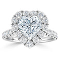 Heart-shaped diamond ring with a halo of round diamonds on a diamond-studded white gold band.