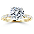 Gold ring with a large round diamond center stone and smaller diamonds set along the band.
