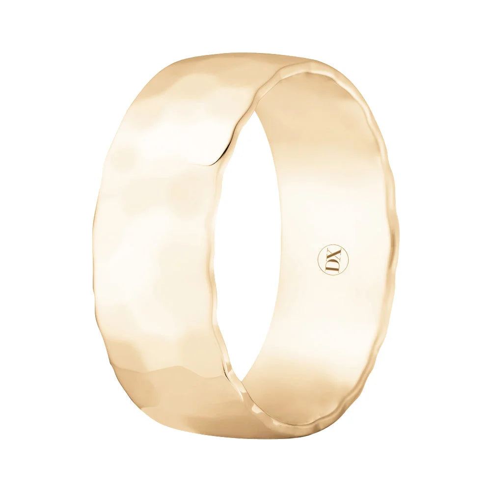 A wide, hammered gold ring with a smooth interior and a small engraved logo inside the band.