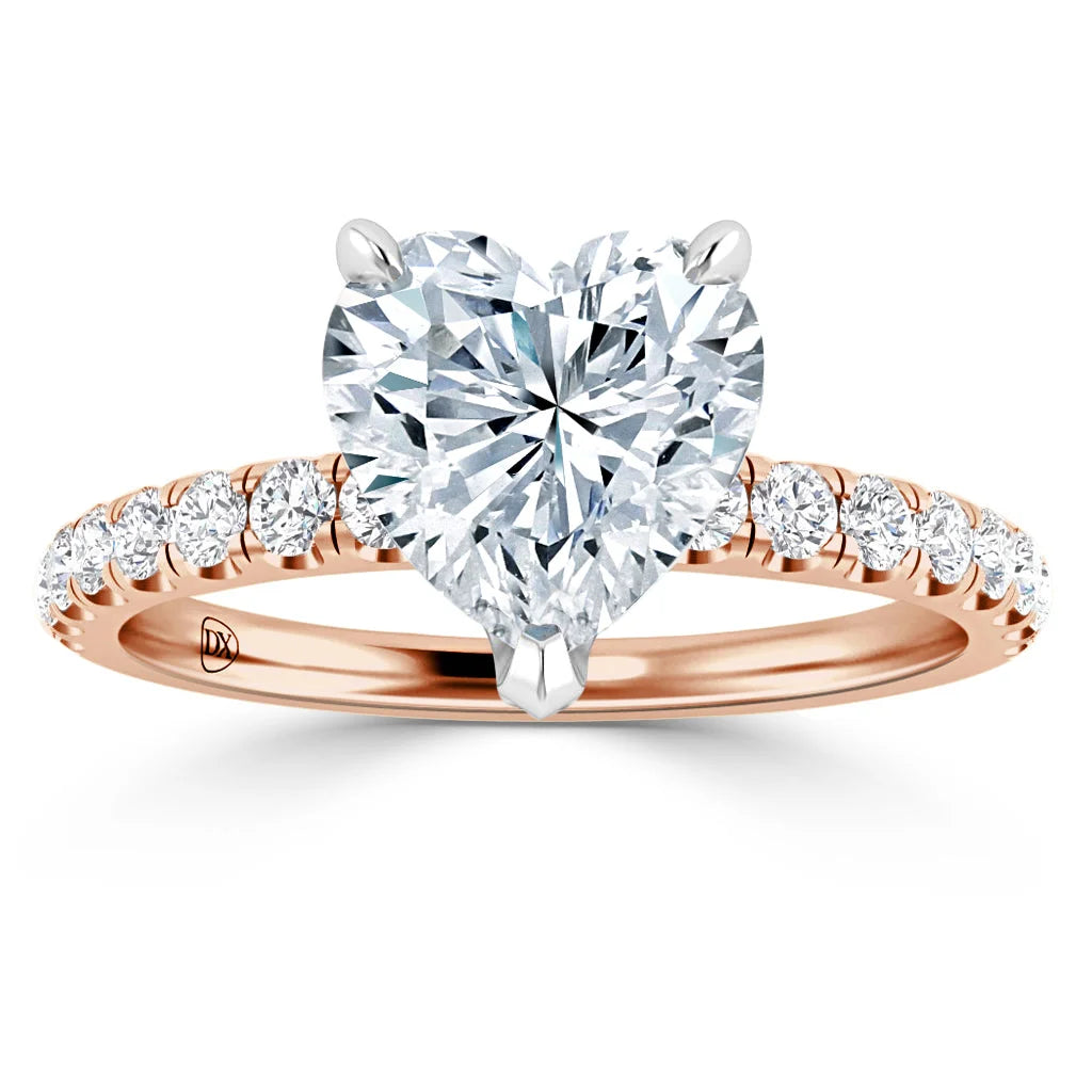A rose gold ring with a heart-shaped diamond center stone and round diamonds set along the band.