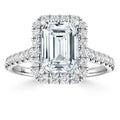 Emerald-cut diamond ring with a halo of small diamonds and a diamond-encrusted band on white background.